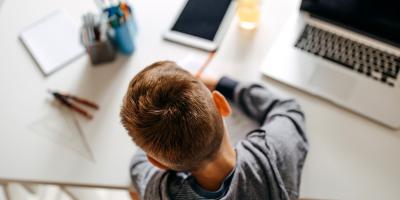 Student sitting at desk at home with technology