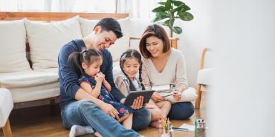 Parents looking at tablet with children