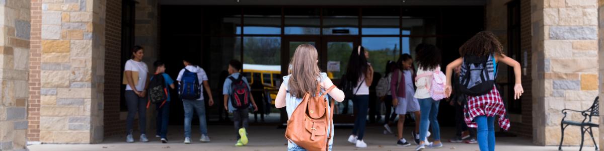 Students running towards a school