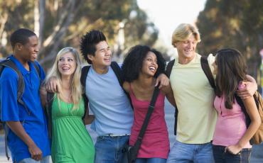 Teens standing in group with arms around each other