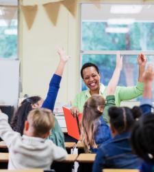 Children with hands up in class