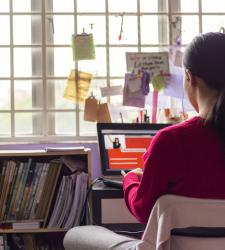 Student sitting in front of laptop engaged in virtual learning.